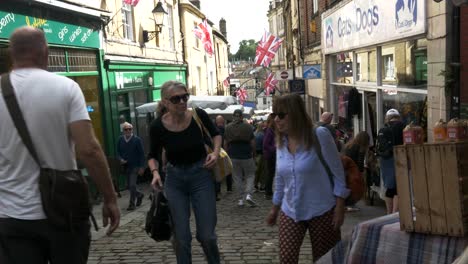 Shoppers-and-tourists-in-a-narrow,-colourful-street-in-Frome-in-rural-England