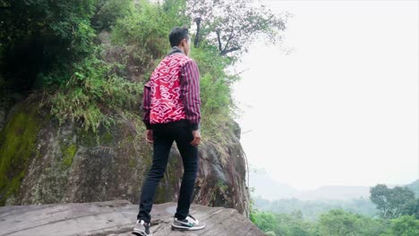 Panorama-of-young-successful-man-hiker-with-open-arms-on-morning-foggy-mountain-peak