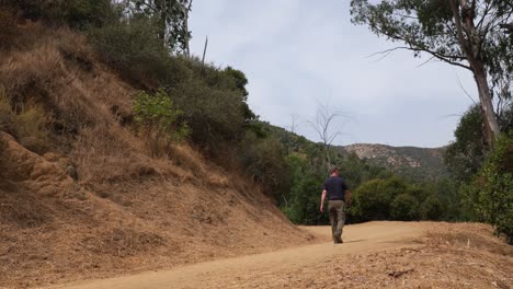 Man-hikes-on-dirt-trail-in-Griffith-Park,-Los-Angeles,-California