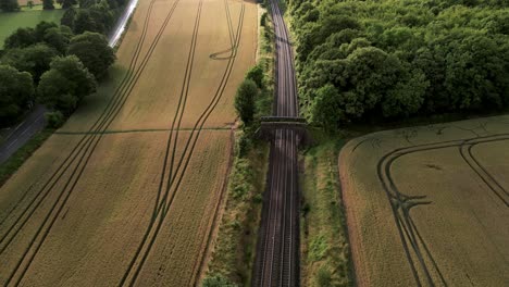 Aerial-View-Of-Railway-Along-The-Fields-With-Ripe-Crops-Ready-For-Harvesting-In-Warminster,-UK