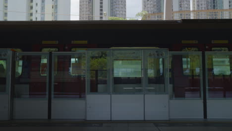 Above-ground-metro-train-waits-at-station-with-doors-closed,-takes-off-and-departs