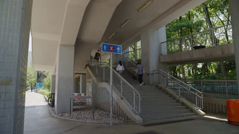 Mother-daughter-walk-up-stairs-to-pedestrian-bridge-in-hong-kong