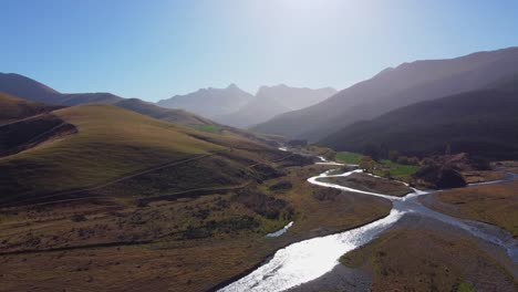 Stunning-braided-river-flows-from-mountains-down-valley-in-autumn-aerial-view