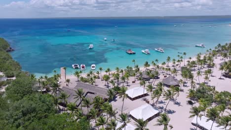 Aerial-View-of-Tropical-Beach-Resort-With-Yacht,-Catamaran,-And-Palm-Trees-On-The-Shore-Of-Isla-Catalina,-Dominican-Republic