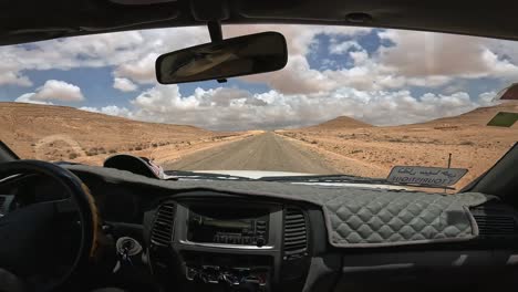 Car-cockpit-point-of-view-during-journey-along-Tunisian-desert-in-Tunisia-on-cloudy-day