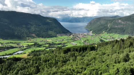 Stunning-village-of-Vik-in-Sogn-presented-from-Storesvingen-viewpoint-along-road---Summer-aerial