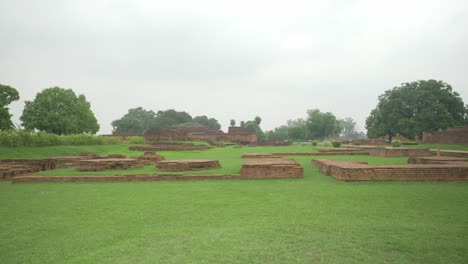 Wide-shot-of-the-ruins-on-the-site-of-Nalanda-Mahavihara-an-ancient-Unesco-World-Heritage-site-famous-as-the-oldest-Buddhist-monastic-university-that-was-demolished-by-Mughal-Invaders,-overcast-cloudy