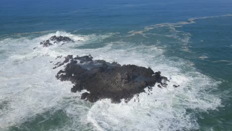 Aerial-view-of-powerful-sea-waves-hits-coral-rock
