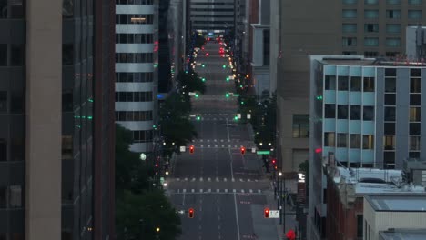 Traffic-lights-on-one-way-street-in-downtown-American-city-at-night
