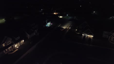 Car-leaving-upscale-American-neighborhood-at-night