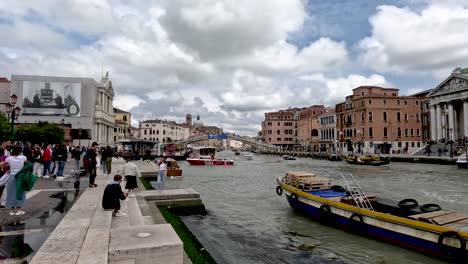 Busy-waters-of-the-Grand-Canal-in-front-of-the-Venezia-Santa-Lucia-railway-station-and-the-distant-Ponte-degli-Scalzi-bridge,-Venice,-Italy