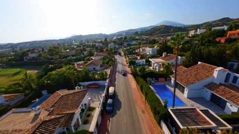 FPV-aerial-drone-tracking-a-Porsche-driving-along-a-picturesque-road-in-Marbella,-Spain