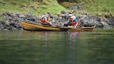 Three-elderly-people-sitting-n-the-boat-near-the-shore