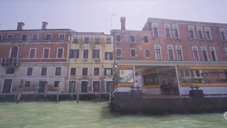 Typische-Venezianische-Architektur,-Gebäude-Und-Paläste-Sowie-Haltestelle-Der-öffentlichen-Verkehrsmittel-Des-Vaporetto.-Blick-Vom-Canal-Grande-Aus-Gesehen-Von-Einem-Vaporetto-Boot-Aus