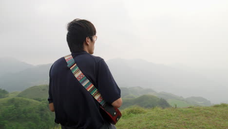 Melodramatic-asian-male-playing-the-ukelele-on-tropical-hilltop-of-Southeast-Asia