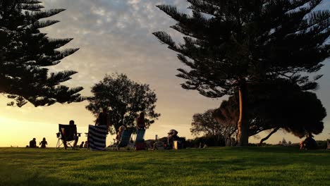 Silhouetten-Von-Menschen,-Die-Sich-Entspannen-Und-Den-Goldenen-Sonnenuntergang-Im-South-Beach-Park-Von-Fremantle-Im-Westen-Australiens-Genießen