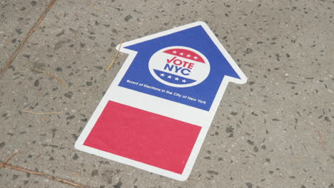 Ein-„Vote-New-York“-Aufkleber-Auf-Dem-Bürgersteig,-Der-Auf-Eine-Wahlkabine-Zeigt