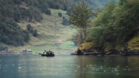 Eine-Dreiköpfige-Familie-Paddelt-Mit-Ihrem-Boot-An-Den-Wunderschönen-Grünen-Ufern-Des-Naeroy-Fjords-Entlang
