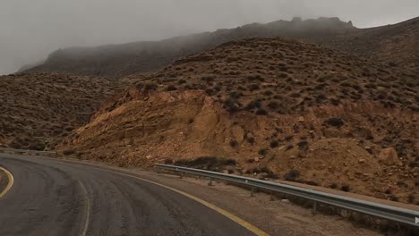 Driving-along-mountain-road-of-Tunisia-on-cloudy-rainy-day,-driver-point-of-view
