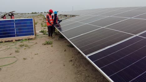 Ingenieros-Y-Trabajadores-De-Energía-Solar-Que-Instalan-Paneles-Fotovoltaicos-En-Una-Granja-Solar-En-Gambia,-África-Occidental