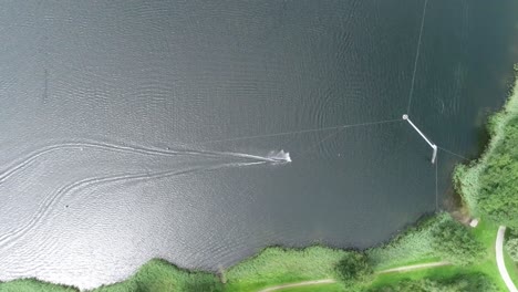 Aerial-drone-shot-of-someone-wakeboarding-at-a-water-sport-park