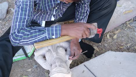 Scene-from-above-in-which-a-sculptor-is-carving-and-carving-a-marble-stone-to-make-an-idol-and-doing-amazing-work