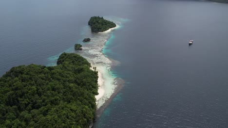 Wunderschöne-Tropische-Insel-Mit-Weißem-Sandstrand-Und-Einer-Phinisi-Yacht-Im-Hintergrund-Im-Letzten-Paradies-Raja-Ampat-Indonesien