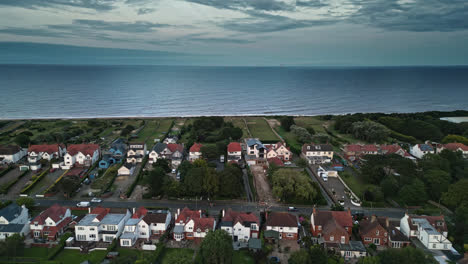 Skegness-coastal-town-seen-from-above-in-drone-footage,-with-holiday-park,-beach,-sea,-and-caravans-during-a-summer-sunset