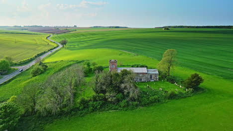 Aerial-drone-footage-showcases-Burwell-village,-formerly-medieval-market-town—surrounding-fields,-aged-red-brick-homes,-and-the-unused-Saint-Michael-parish-church-on-Lincolnshire's-Wold-Hills