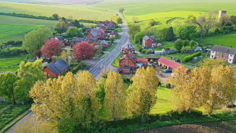 Drone-video-presents-Burwell-village,-once-a-medieval-market-town,-featuring-countryside-fields,-old-red-brick-houses,-and-the-decommissioned-Saint-Michael-parish-church-on-the-Wold-Hills
