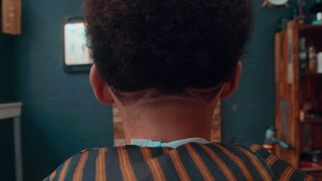 Beautiful-close-up-slow-motion-shot-of-the-result-of-an-afro-haircut-in-barbershop-by-a-professional-barber-to-a-young-man