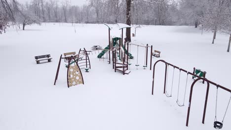 Frozen-kids-playground-in-local-park-in-winter-season,-aerial-drone-view