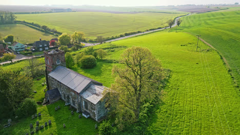 Drone-imagery-reveals-Burwell-village,-history-as-medieval-market-town—surrounded-by-countryside-fields,-vintage-red-brick-houses,-and-the-abandoned-Saint-Michael-parish-church-on-Lincolnshire's-Wolds
