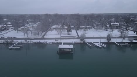 Residential-buildings-and-piers-on-Detroit-river-bank,-along-Grosse-Ile-aerial-drone-view-on-winter-season