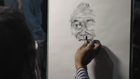 Zeitlupenaufnahme-Eines-Straßenkünstlers,-Der-Mit-Kohle-Ein-Porträt-Eines-älteren-Mannes-Zeichnet
