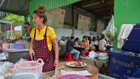 Zwei-Frauen-Schneiden-Gegrilltes-Schweinefleisch-In-Scheiben,-Plattieren-Es-Und-Verteilen-Es-An-Ihre-Wartenden-Kunden