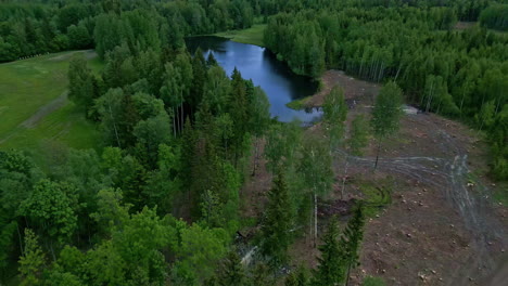 Aerial-View-Of-Lake-in-a-Lush-Green-Forest-with-Pull-Out-Reveal-Shot,-Latvia