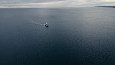 Drohnenaufnahme-Eines-Fischerbootes,-Das-Landeinwärts-In-Richtung-Scarborough-Fährt