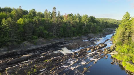 River-in-Minnesota-in-the-middle-of-a-forest,-nature-landscape-during-golden-hour-Aerial-view