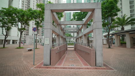 Handheld-shot-of-concrete-pathway-leading-to-residential-tower-square