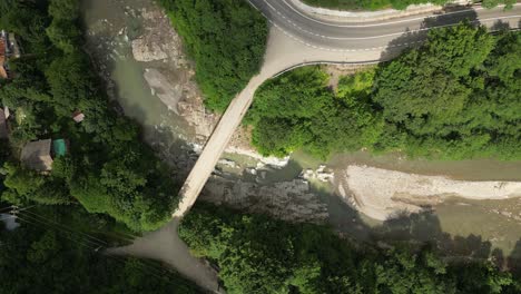 Top-down-drone-lifting-shot-of-a-bridge-over-the-Putna-river-in-Romania