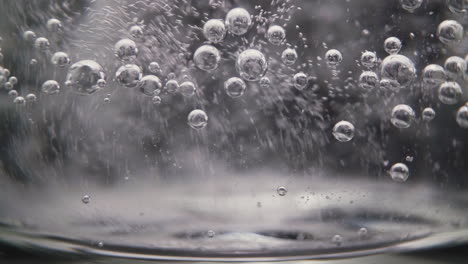 glass-with-vitamin-water-and-small-bubbles-on-clear-wall