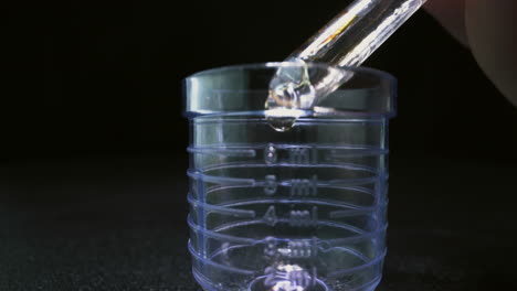 dripping-antiviral-vaccine-into-volumetric-flask-from-ampule
