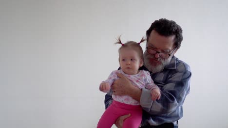 Grandfather-with-a-beard-wearing-glasses-playing-with-a-little-adorable-granddaughter-2