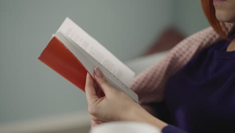 Woman-runs-through-pages-of-book-looking-for-certain-part