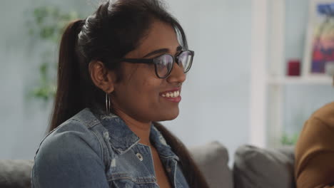 Mujer-India-Con-Cola-De-Caballo-Sonríe-Viendo-Una-Película-De-Comedia