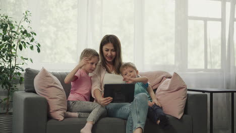 Mother-and-children-talk-to-father-on-video-call-via-tablet