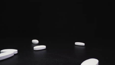Verter-Medicamentos-Antivirales-Blancos-Sobre-La-Superficie-Negra-Vista-Cercana