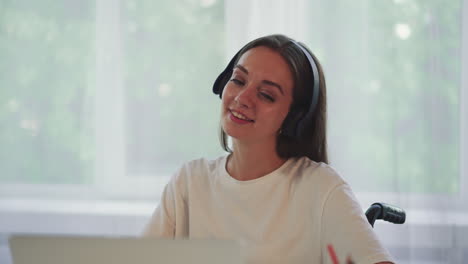 Happy-woman-in-headphones-enjoys-favorite-song-while-working