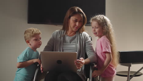 Curious-children-watch-freelance-mother-working-on-laptop